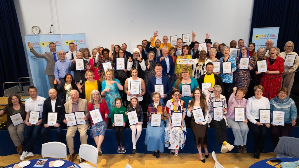 The groups of winners facing the official photographer smiling and cheering and holding either their winners or champions certificates