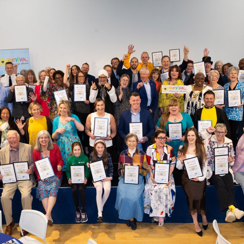 The groups of winners facing the official photographer smiling and cheering and holding either their winners or champions certificates