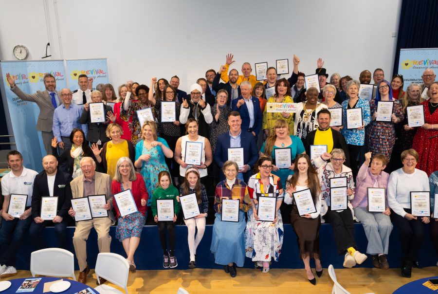 The groups of winners facing the official photographer smiling and cheering and holding either their winners or champions certificates